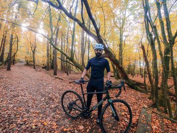 Man riding bicycle on autumn leaves