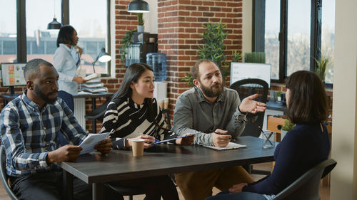 Portrait of smiling friends using digital tablet in cafe