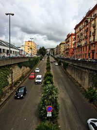 Cars on road in city against sky