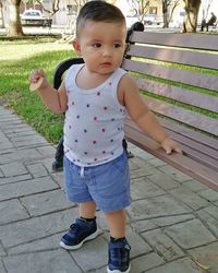 Portrait of cute boy standing on footpath