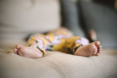 Bare feet of newborn baby sleeping on sofa