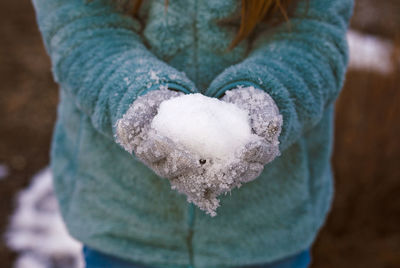 Midsection of woman holding snow