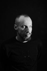 Portrait of man against black background