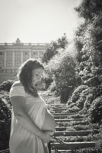 Side view of woman standing in front of building