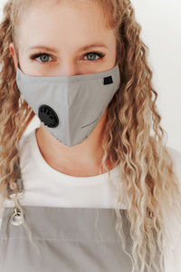 Portrait of woman wearing mask against white background