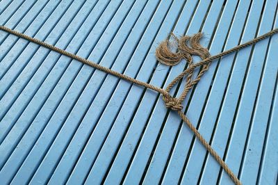 High angle view of tied rope on boardwalk
