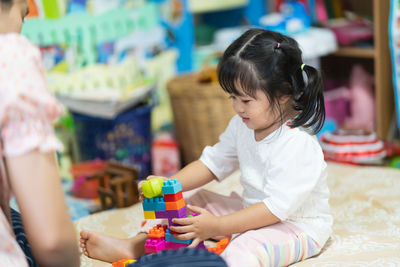 Rear view of a girl sitting with toy