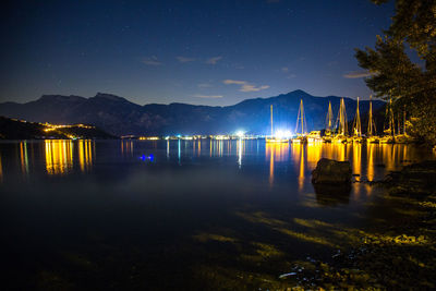 Scenic view of lake against sky at night