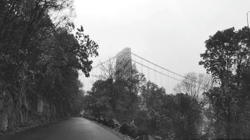 Road amidst trees against clear sky