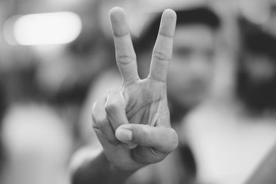 Man gesturing peace sign outdoors