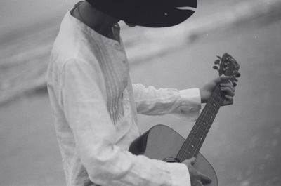 Midsection of man playing guitar