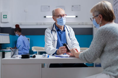 Doctor wearing mask examining patient in hospital