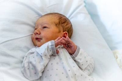 High angle view of cute baby sleeping on bed