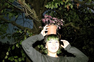 Portrait of young woman with green leaves