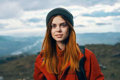 Portrait of beautiful young woman standing in park during winter