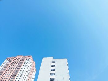 Low angle view of buildings against clear blue sky