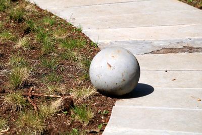 High angle view of stone ball on footpath