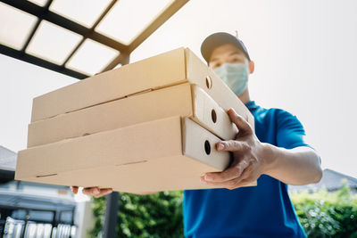 Full length of boy holding camera in box