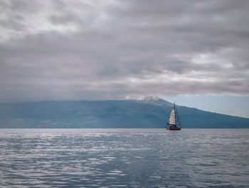 Sailboat sailing on sea against sky