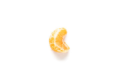 Close-up of orange slice over white background