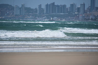 Scenic view of sea against buildings in city