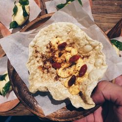 Close-up of hand holding bread on table