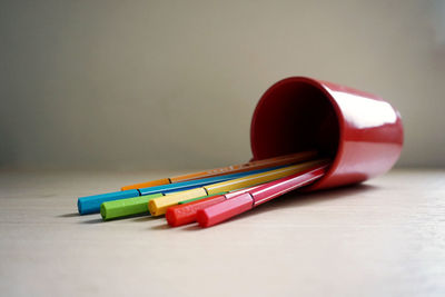 Close-up of multi colored pens in case on table