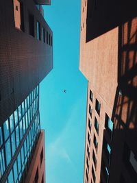 Directly below shot airplane flying over buildings in city