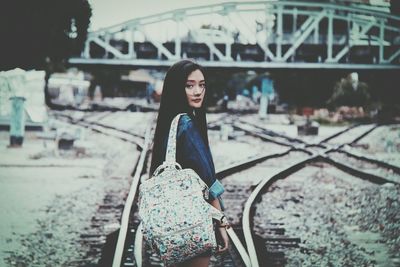 Portrait of woman standing on railroad track