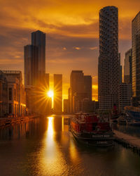 Modern buildings against sky during sunset