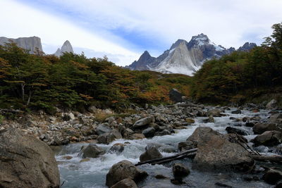 Scenic view of river and mountains against sky