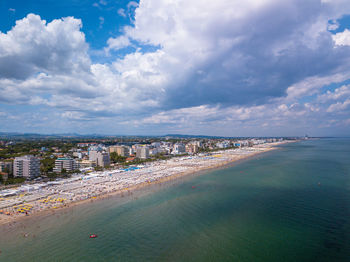 High angle view of city by sea against sky