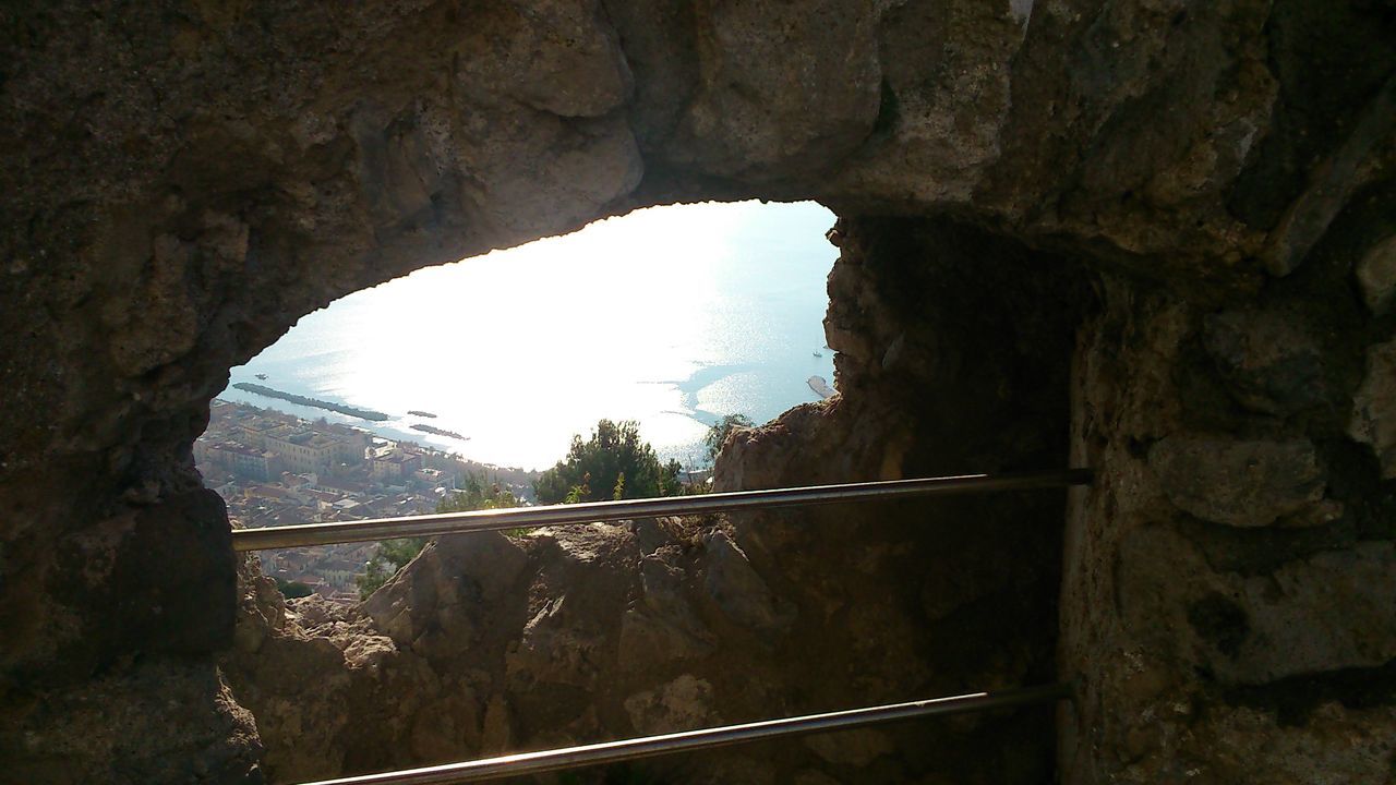 indoors, arch, water, nature, tranquility, rock formation, rock - object, tree, reflection, tranquil scene, window, beauty in nature, mountain, sunlight, day, scenics, cave, river, sky, no people