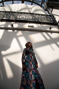 Low angle view of fashion model posing against wall