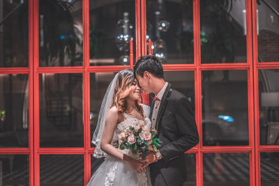 Young couple standing against wall