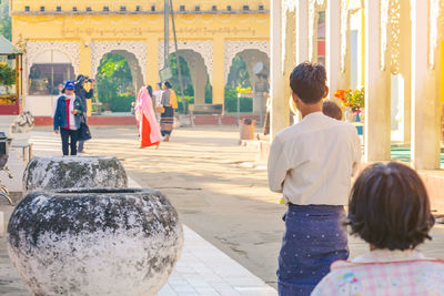 Rear view of people walking outside temple