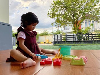 Girl playing with toy sitting on table