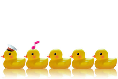 Close-up of yellow toys over white background