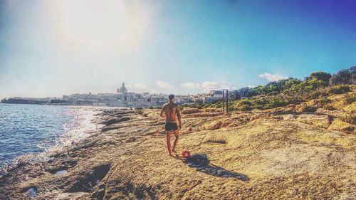 Side view of man on beach against sky