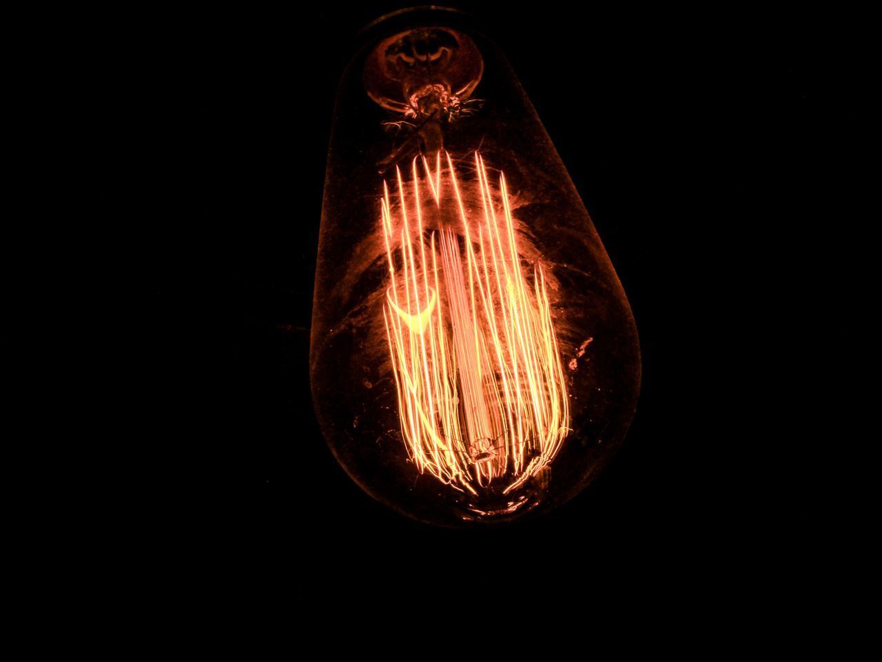 CLOSE-UP OF LIGHT BULB AGAINST BLACK BACKGROUND