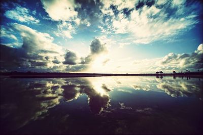 Reflection of clouds in sea at sunset