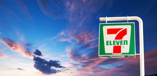 Low angle view of road sign against blue sky