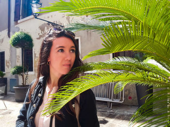 Portrait of young woman with palm leaves