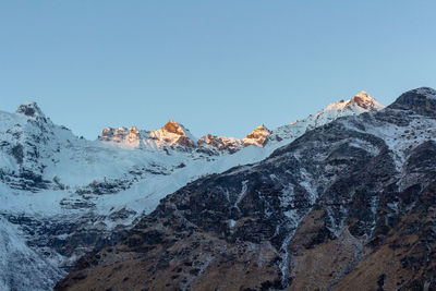 Scenic view of snowcapped mountains against clear blue sky