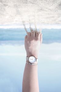 Midsection of woman with arms raised against sea