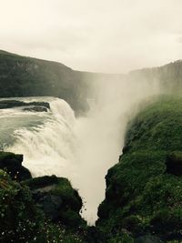 Scenic view of waterfall against sky