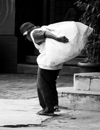 Full length of man carrying bag on shoulder