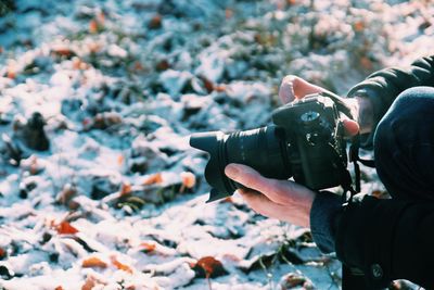 Midsection of man photographing on land