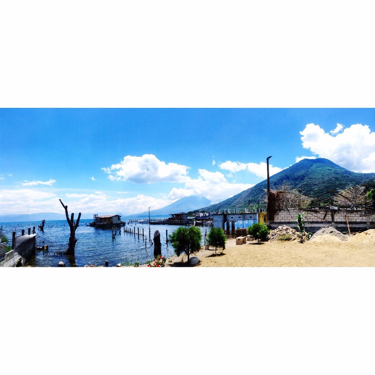 sky, beach, water, sea, tranquil scene, scenics, tranquility, sand, blue, nature, shore, beauty in nature, cloud - sky, mountain, cloud, horizon over water, idyllic, built structure, day, thatched roof