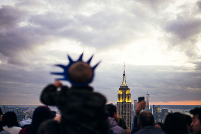 People watch from skyscrapers the buildings of new york at sunset and take photos with the mobile, united states
